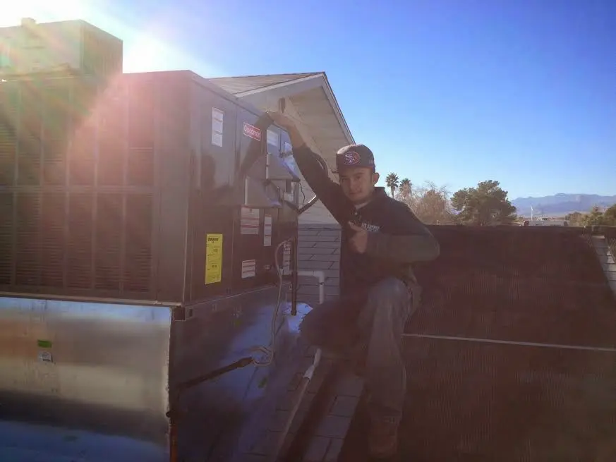 HVAC technician performing AC Tune-Up on a rooftop unit in West Lafayette
